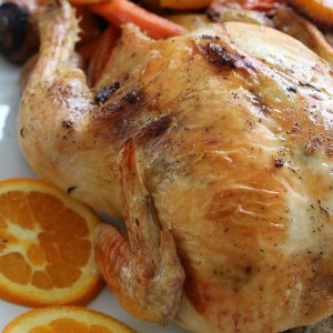 a white tray with a whole roasted chicken
