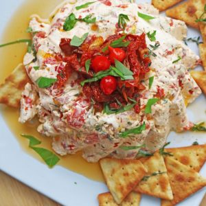 This-easy-cheese-appetizer-is-covered-with-sun-dried-tomatoes-and-loaded-with-three-types-of-cheese,-olives,-roasted-pepper