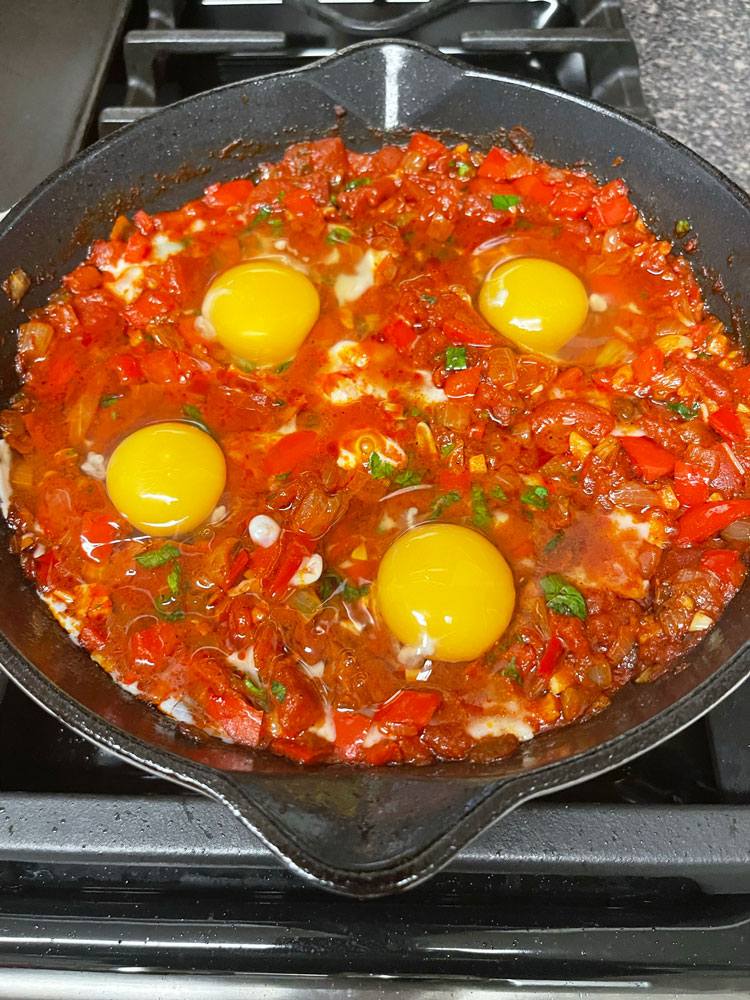 Using the back of a large spoon, create a well that's slightly larger than an egg. Place one egg in each well, and repeat the process with the remaining eggs. Egg-recipe