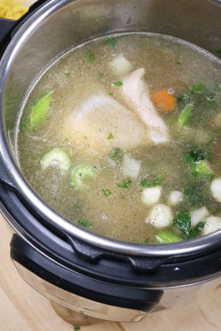 HOW TO MAKE INSTANT POT CHICKEN NOODLE SOUP Pour-in-the-chicken-broth.-Add-the-chicken-pieces-and-addย -four-cups-of-water