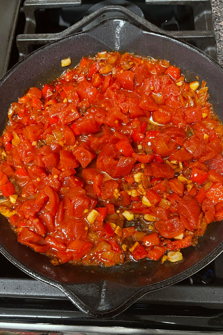 Stir in the tomatoes, using a wooden spoon to break them into small chunks. Place the mixture on medium heat and wait until it boils. Stir in the tomatoes, using a wooden spoon to break them into small chunks. Place the mixture on medium heat and wait until it boils.