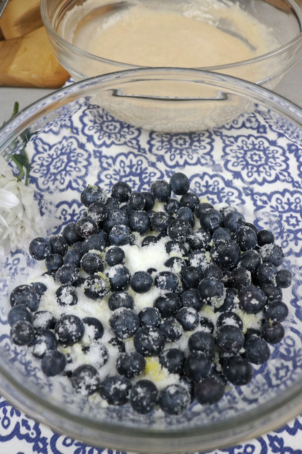 The addition of lemon juice and zest to the blueberry mixture adds a bright, fresh flavor that perfectly complements the sweetness of the fruit. Add-blueberries,-sugar,-and-zest-to-a-bowl-and-stir-to-combine.