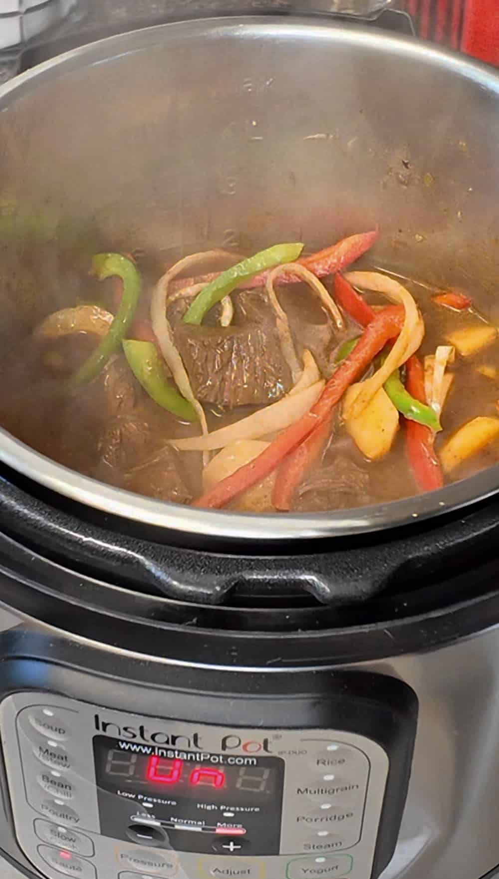 Set the pressure cooker to sautรฉ mode again and add Spanish olives, cilantro, tomato paste, and red wine vinegar. Also, add red and green peppers. If desired, you can add white onions and 2 potatoes, although these are optional. Set the pressure cooker to sautรฉ mode again and add Spanish olives, cilantro, tomato paste, and red wine vinegar. Also, add red and green peppers. If desired, you can add white onions and 2 potatoes, although these are optional.