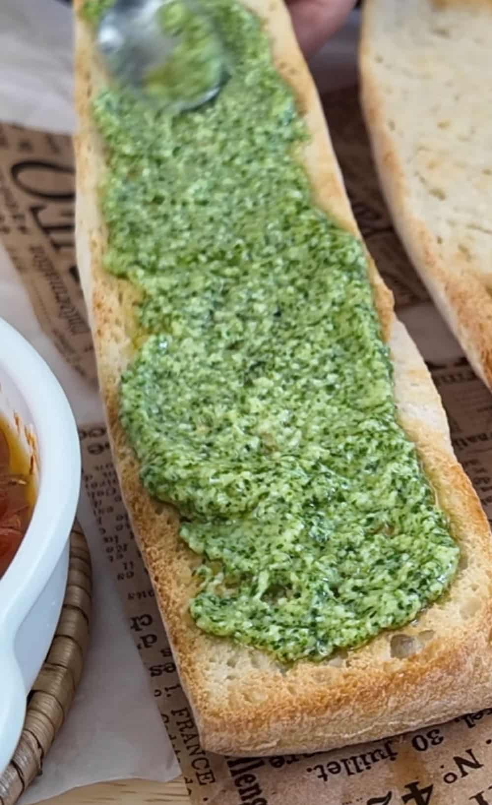 Spread pesto on the bottom half of the toasted bread, and layer fresh arugula on top. Spread-the-bread-with-the-homemade-pesto