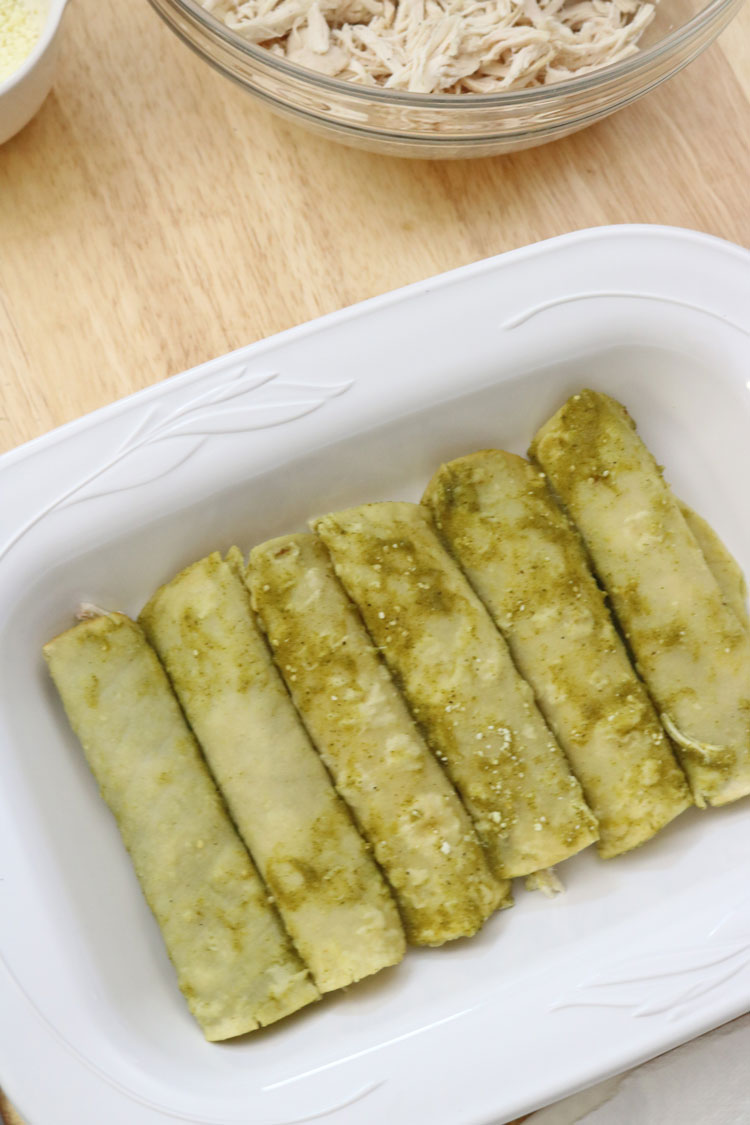 Arrange the rolled tortillas seam-side down on a serving dish. Place-a-portion-of-shredded-chicken-in-the-center-of-each-tortilla-and-roll-it-up.-Arrange-the-rolled-tortillas-seam-side-down-on-a-serving-dish.