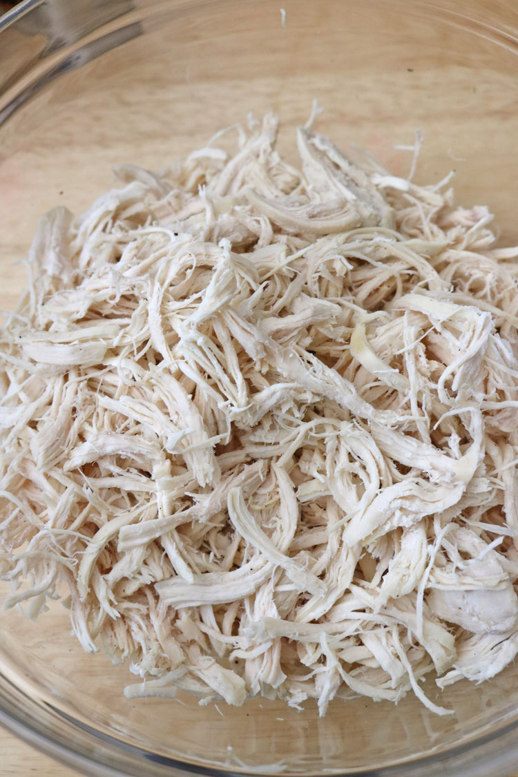 For the chicken to be extra moist, add a little bit of the liquid from the pan to the chicken and toss to combine. Use-two-forks-to-pull-the-chicken-apart-into-shreds.