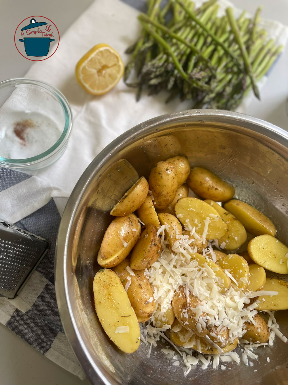 In a large bowl, toss the halved fingerling potatoes and the asparagus with paprika, oregano, thyme, garlic powder, and olive oil. Make sure each piece is well-coated. If is your preference season the potatoes and asparagus separately. Easy-Parmesan-Potato-Recipe