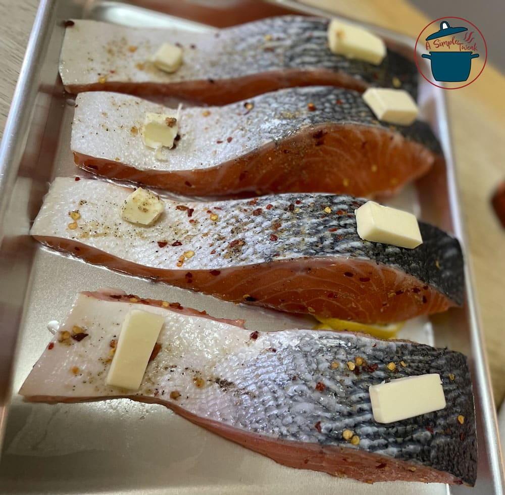Place them on the baking sheet. Add lemon slices under the thickest part of the salmon, and add 2 slices of unsalted butter on both ends of the fish. Looking-for-a-quick-and-easy-dinner-option-that-is-on-the-table-in-less-than-20-minutes.-I-have-the-perfect-recipe-for-you