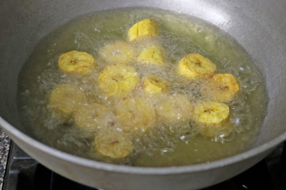 Next,-heat-oil-in-a-heavy-bottomed-frying-pan-over-medium-heat.-When-the-oil-is-hot,-fry-the-plantains-chunks-until-golden-brown-and-cooked-through,-making-sure-not-to-overcrowd-the-pan. Next,-heat-oil-in-a-heavy-bottomed-frying-pan-over-medium-heat.-When-the-oil-is-hot,-fry-the-plantains-chunks-until-golden-brown-and-cooked-through,-making-sure-not-to-overcrowd-the-pan.